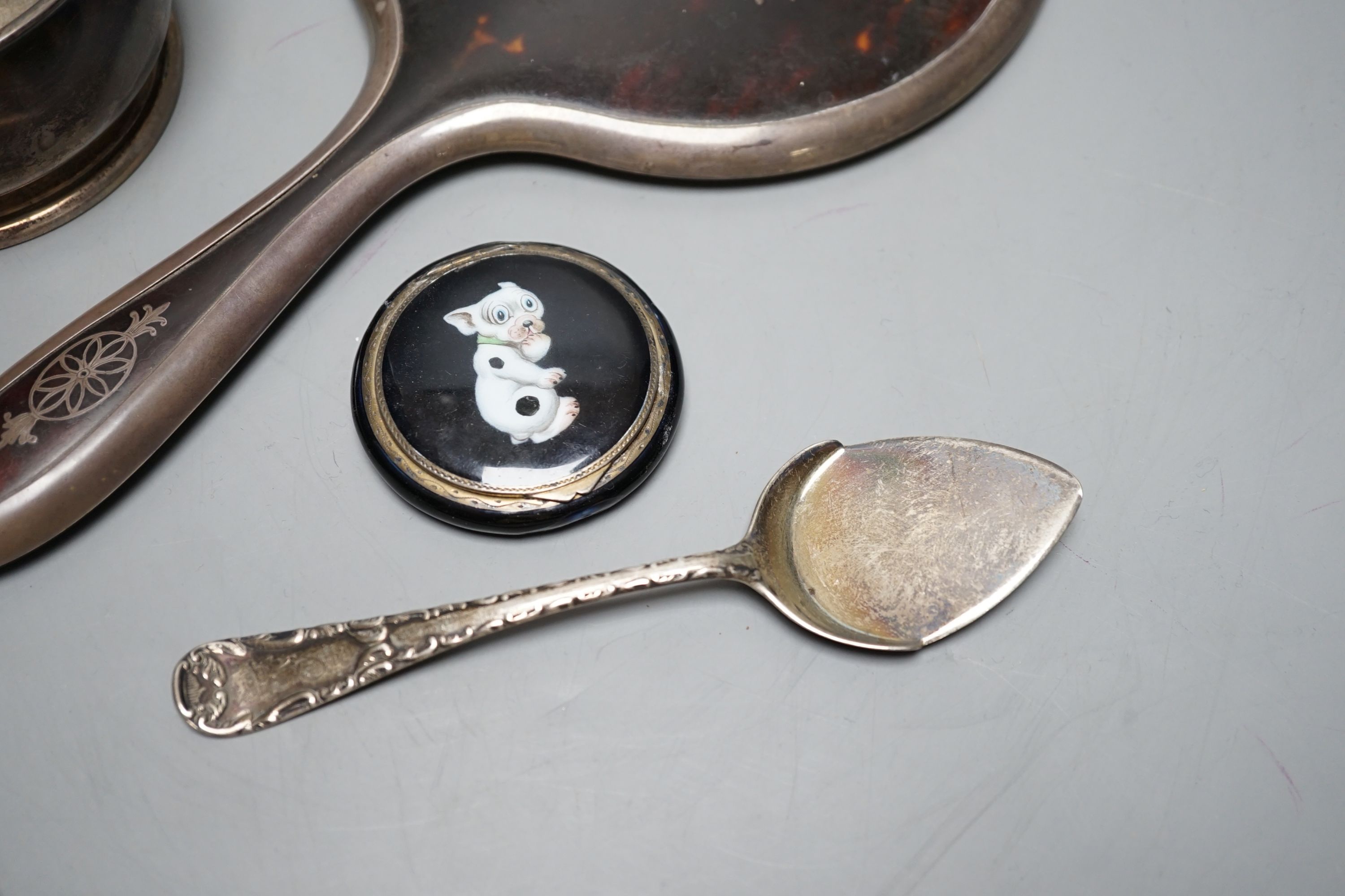 A silver two handled bowl, a silver mounted hand mirror, two silver and mother of pearl fruit knives, a silver preserve spoon and enamelled compact decorated with a dog.